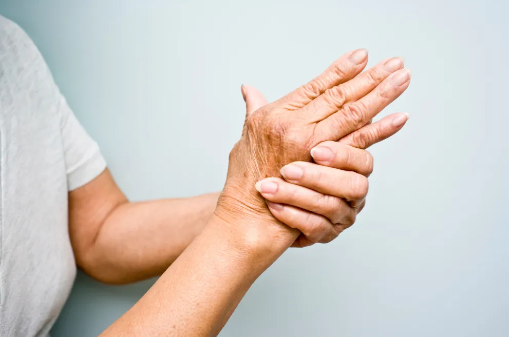 Older woman holding one hand in the other