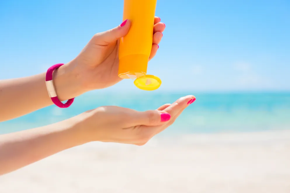 Woman's hands squeezing sunscreen