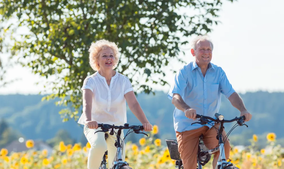 Active elderly coupon riding bicycles in the countryside