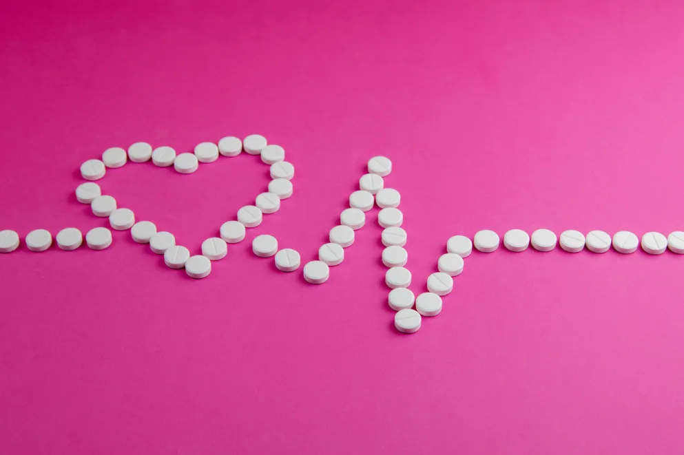 Aspirin tablets in shape of heart and heart rhythm