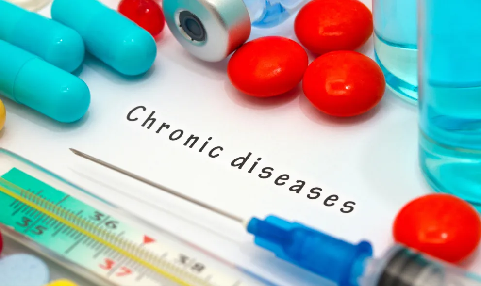 Chronic disease diagnosis written on white paper with a syringe and drugs
