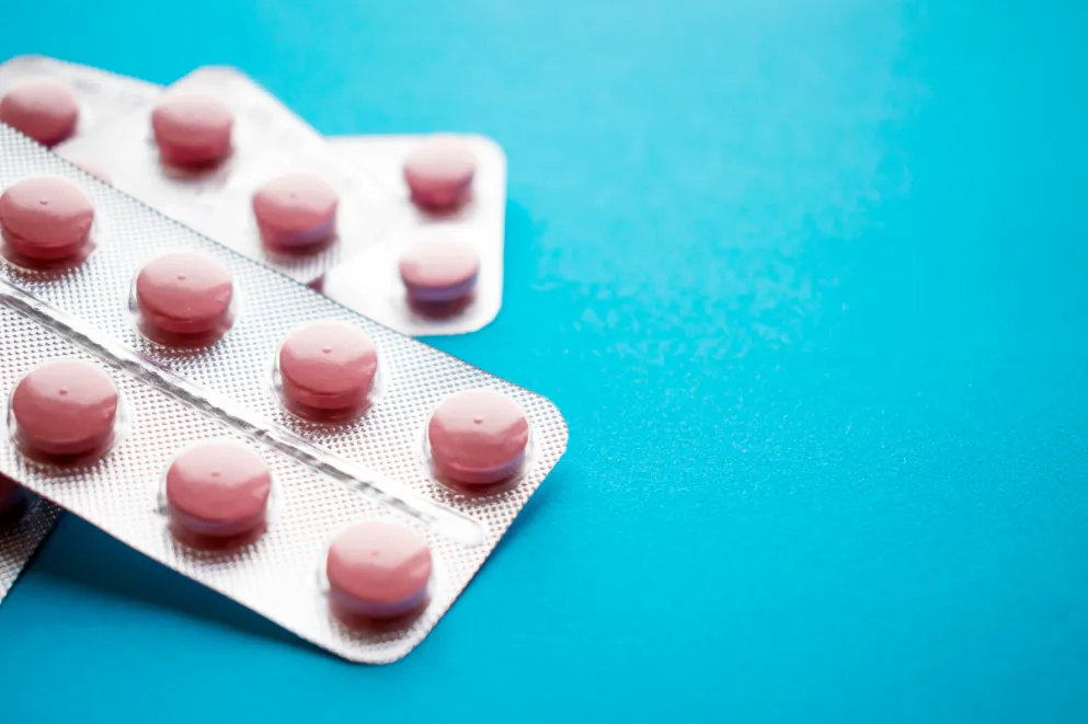 Close up of statin pills in blister pack on blue background