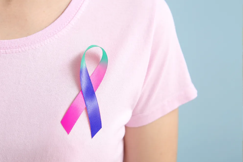Close up of woman in pink shirt wearing thyroid awareness ribbon