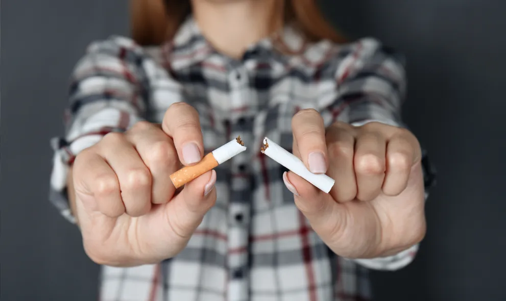Closeup view of woman breaking cigarette in hands