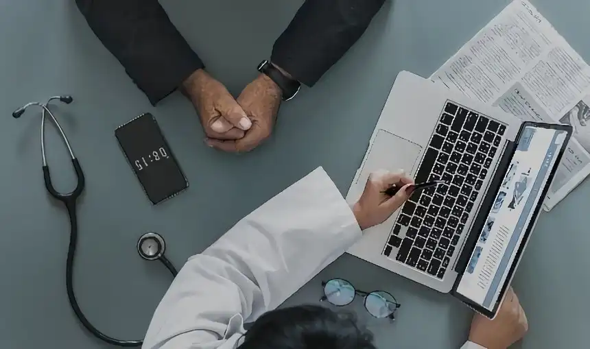 Doctor with patient siscussing results on laptop computer