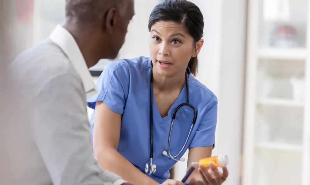 Concerned doctor speaks with senior patient about medication side effects