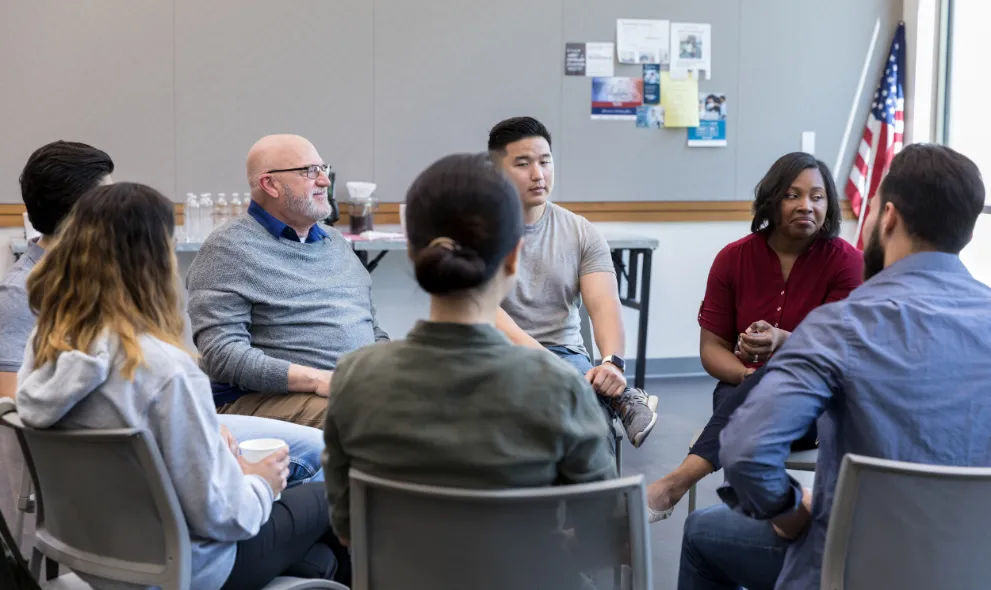 Diverse group of people sitting in circle for group therapy