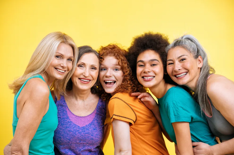 Diverse group of women smiling with yellow background