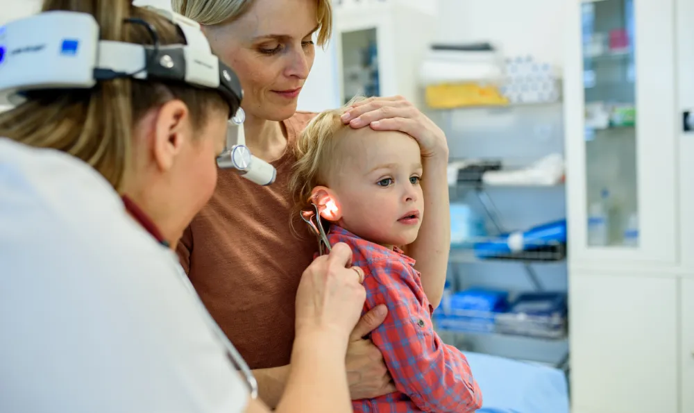 Doctor checking childs ear