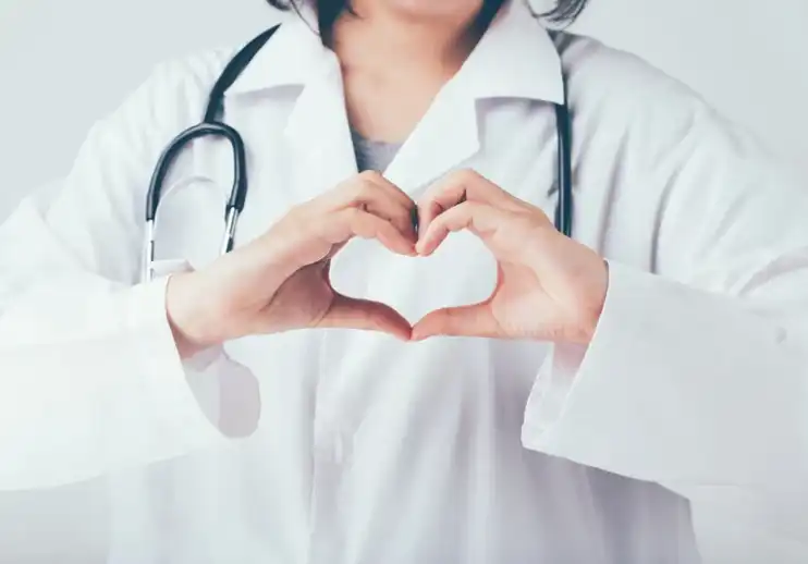 Doctor making hand gesture of heart