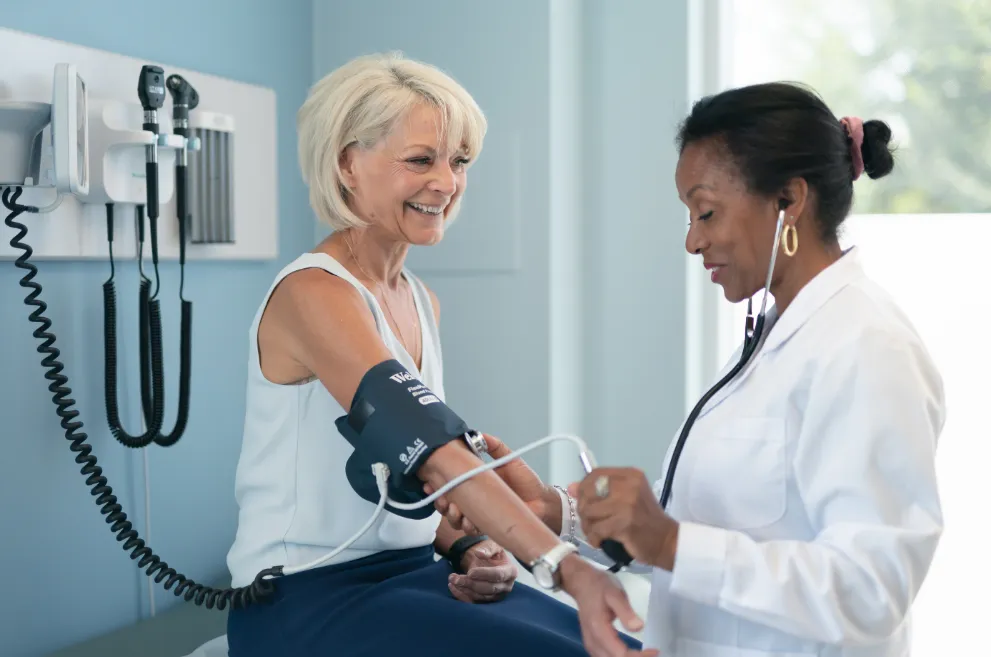 Doctor taking female patient's blood pressure