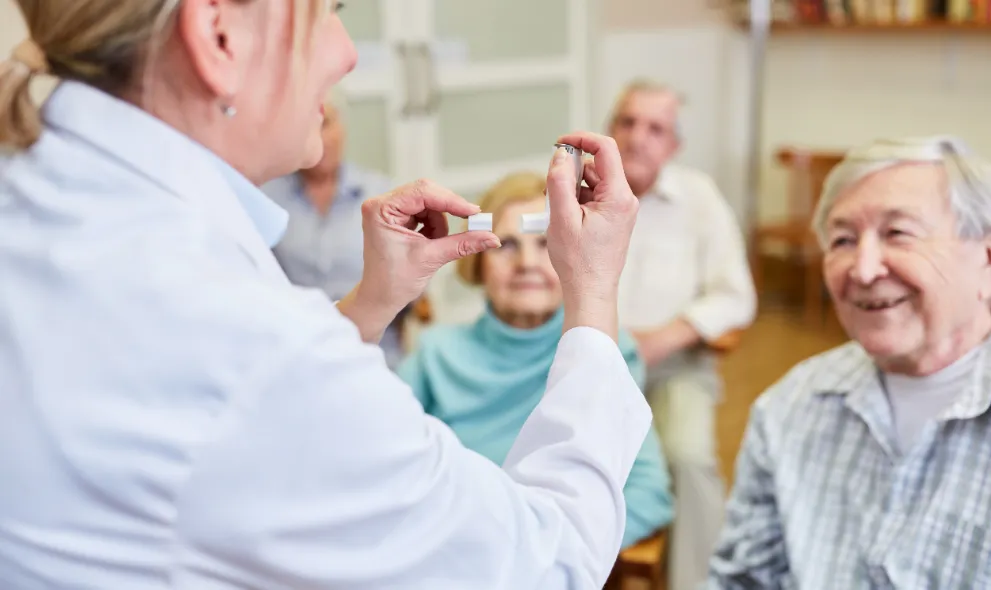 Doctor teaching seniors how to use inhaler