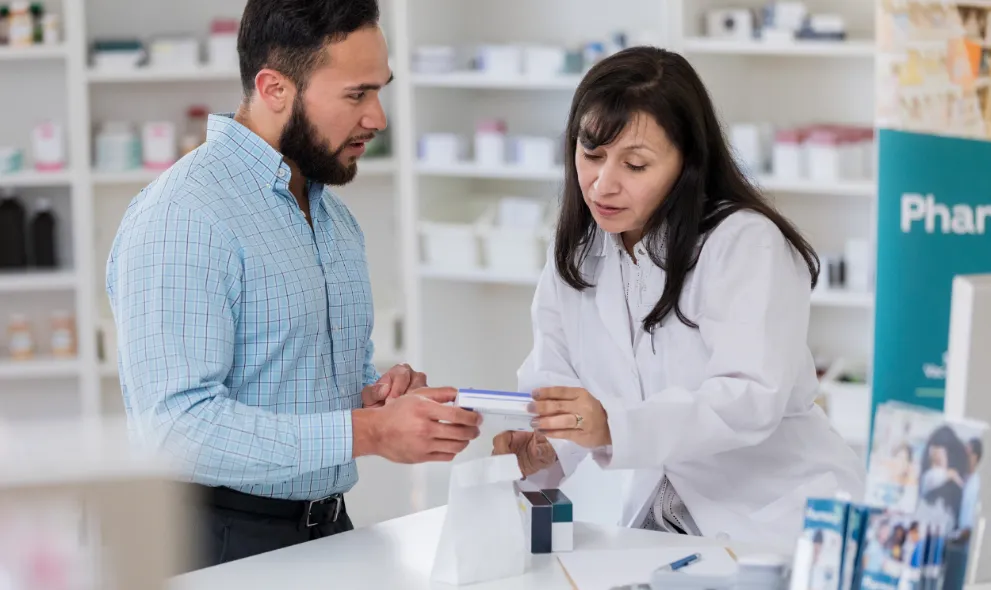 Female pharmacist helps male patient with medication instructions