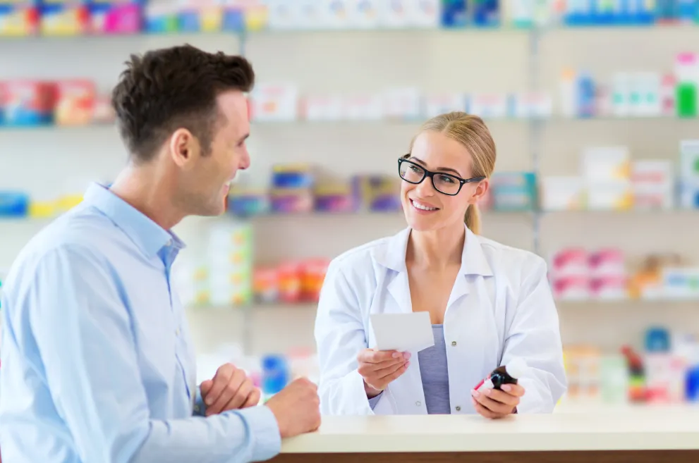 Female pharmacist talking to male customer