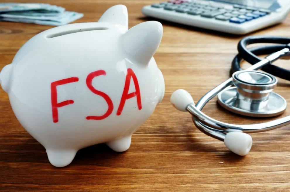 FSA wrote in red ink on side of piggy bank with a stethoscope and calculator