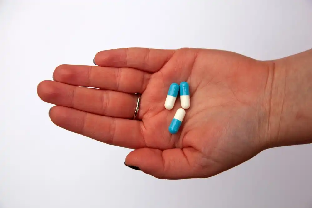 Hand holding a few capsule medications