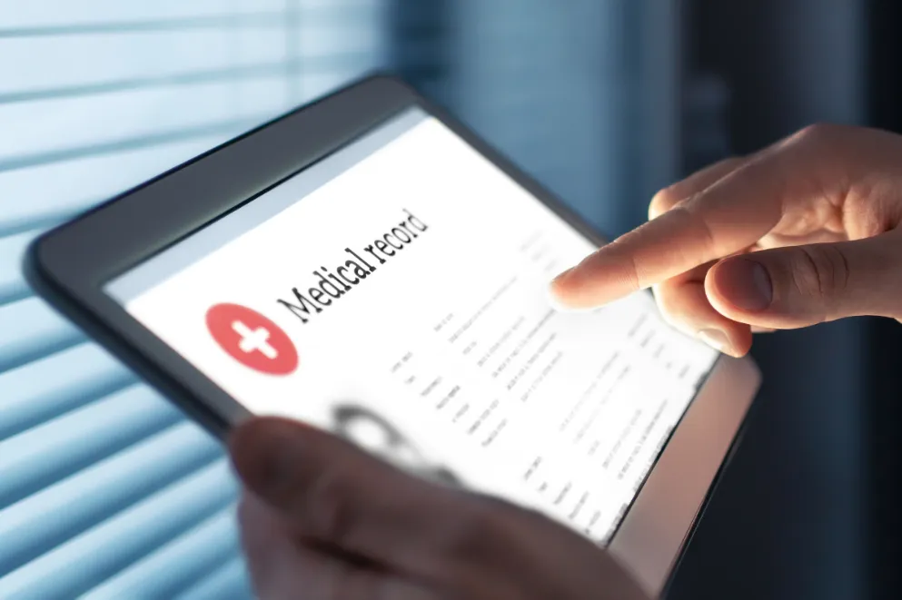 Hands Holding Tablet Displaying Medical Record