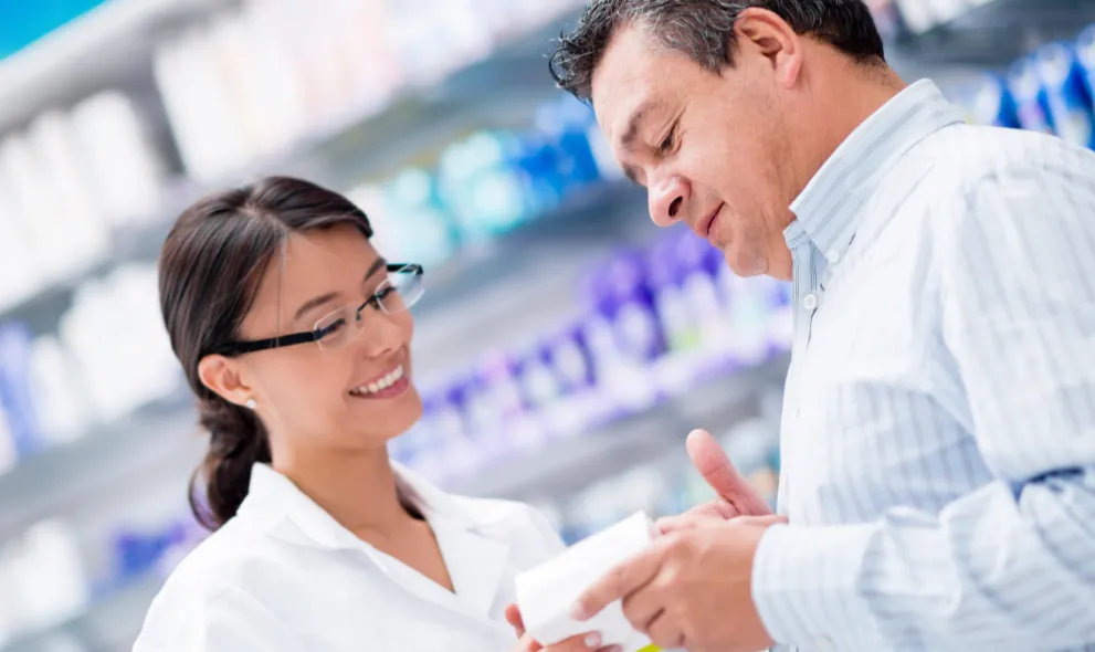 Happy pharmacist talking to patient about prescription medication