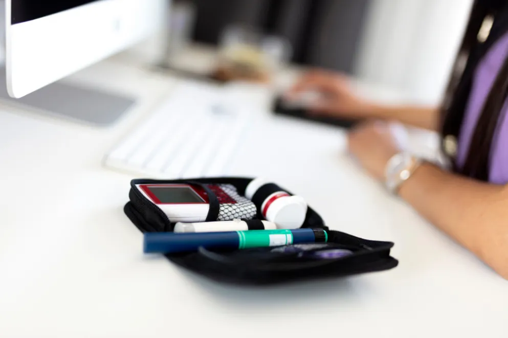 Insulin equipment with woman using computer in background