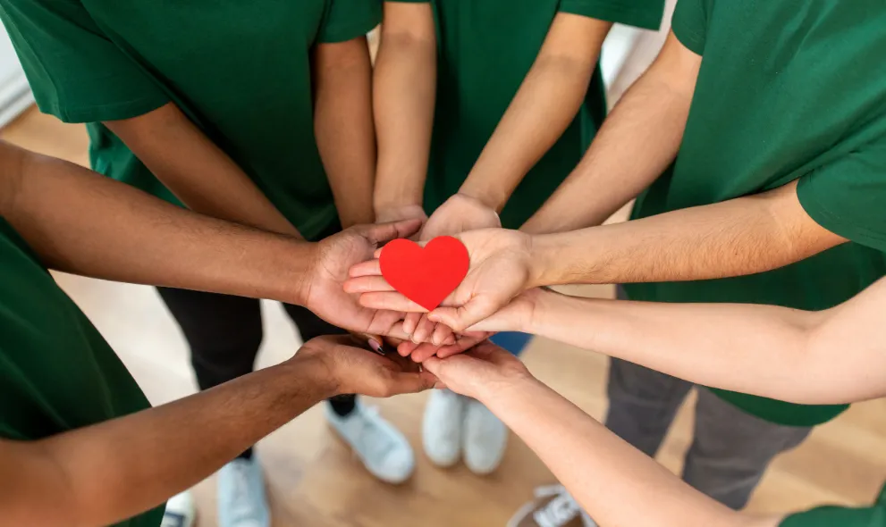 Lots of hands holding a heart