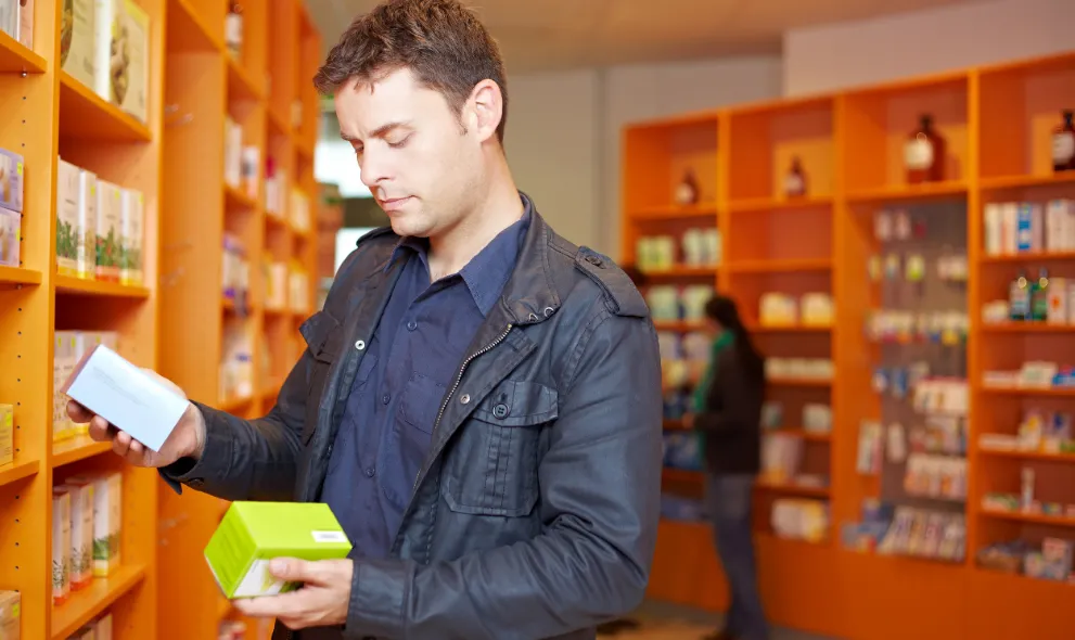 Man comparing two medications in pharmacy