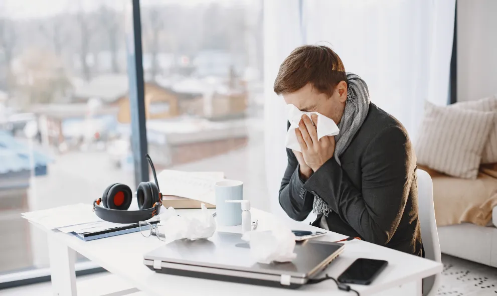 Man suffering with allergies sitting at desk
