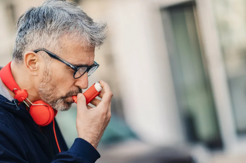 Man using asthma inhaler