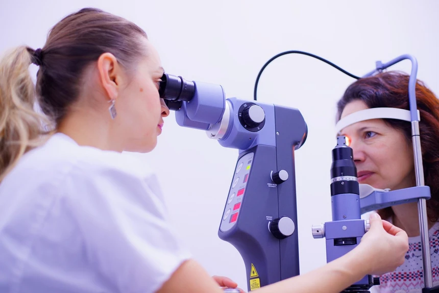 Tech inspecting patient eyes