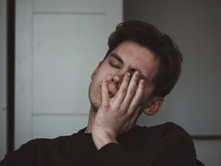 Man pictured holding head in hands, sleeping