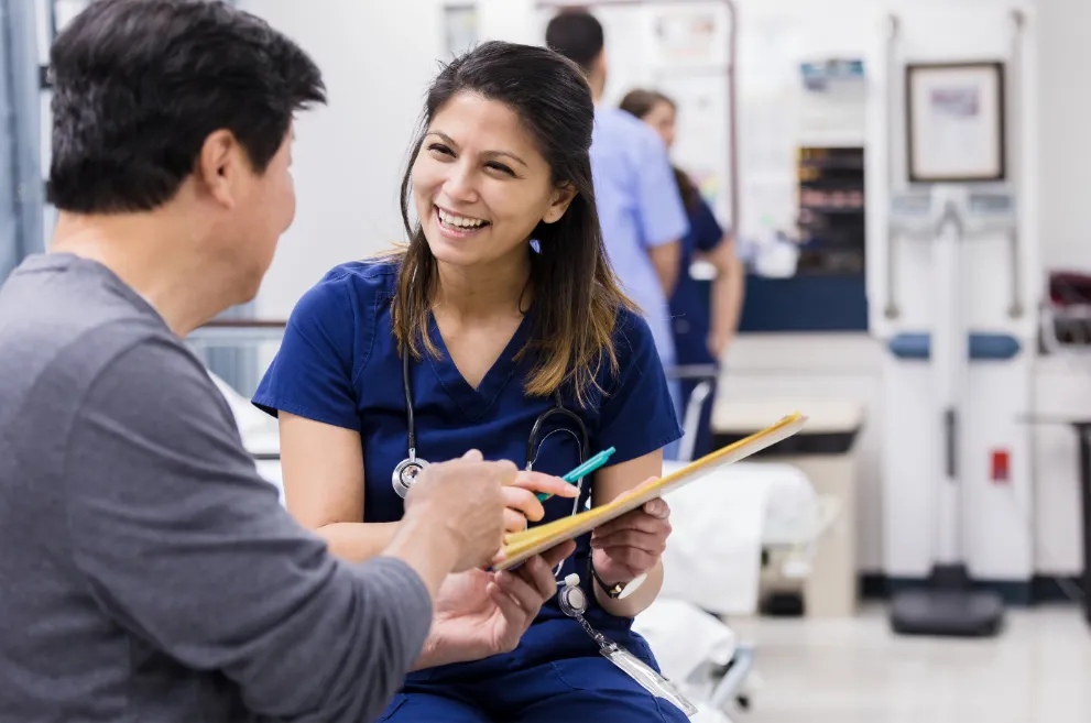 Medical professional looking at papers with patient