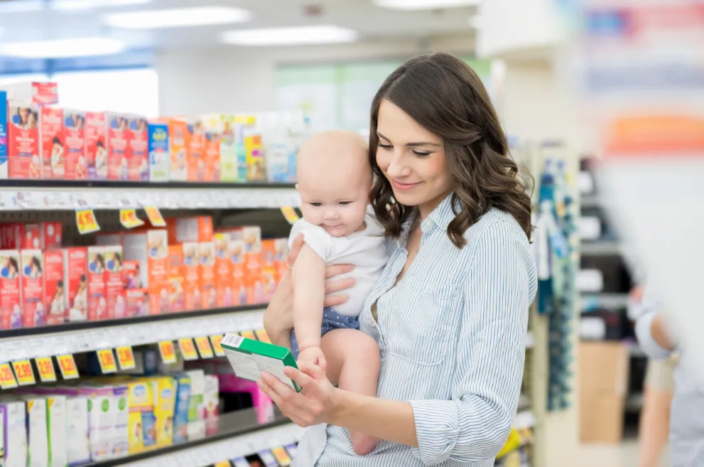 Mom and baby in pharmacy looking at medicine