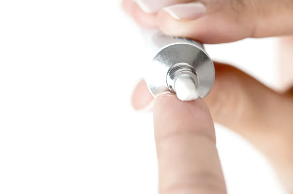 Ointment being squeezed out of tube onto finger