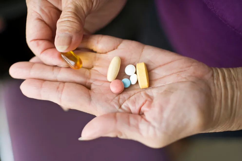 Older woman's hands holding pills