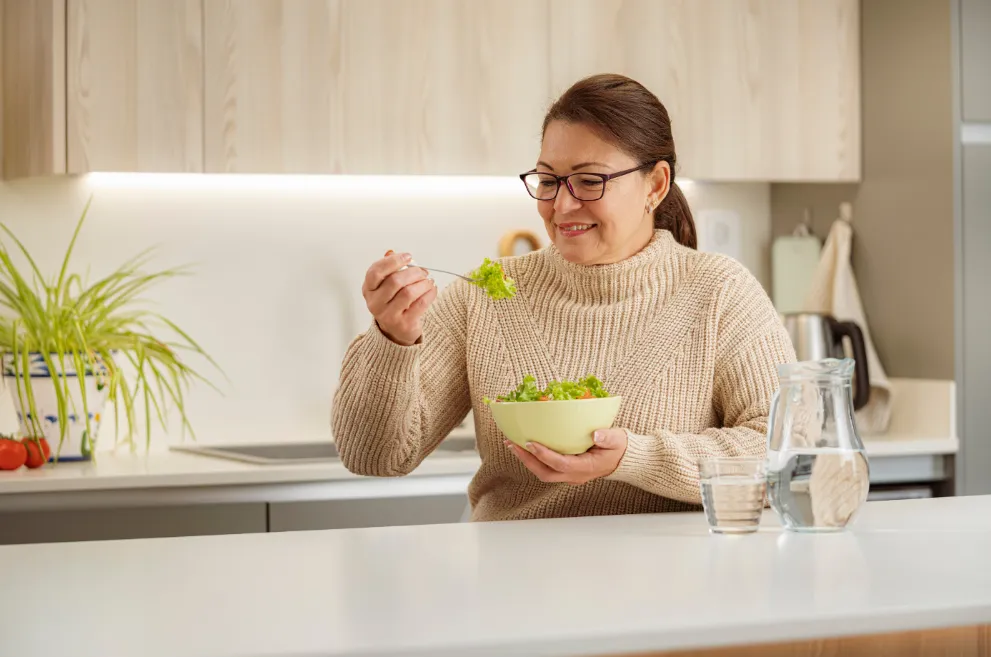 Older woman smiling and eating healthy food
