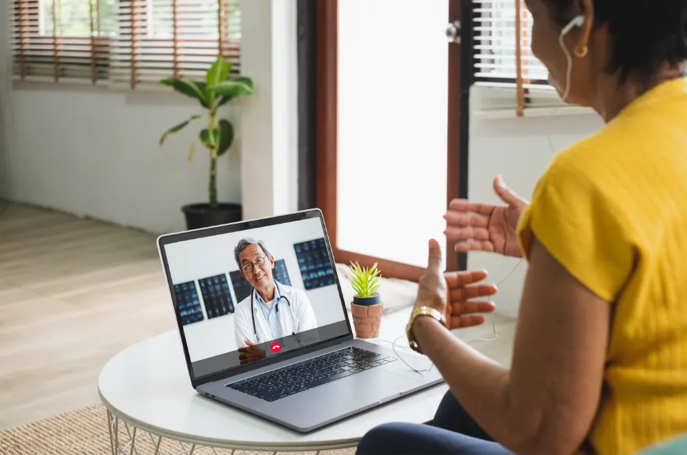 Patient talking to doctor via laptop