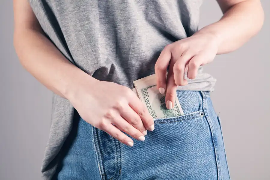 Person Putting Bills Into Pocket