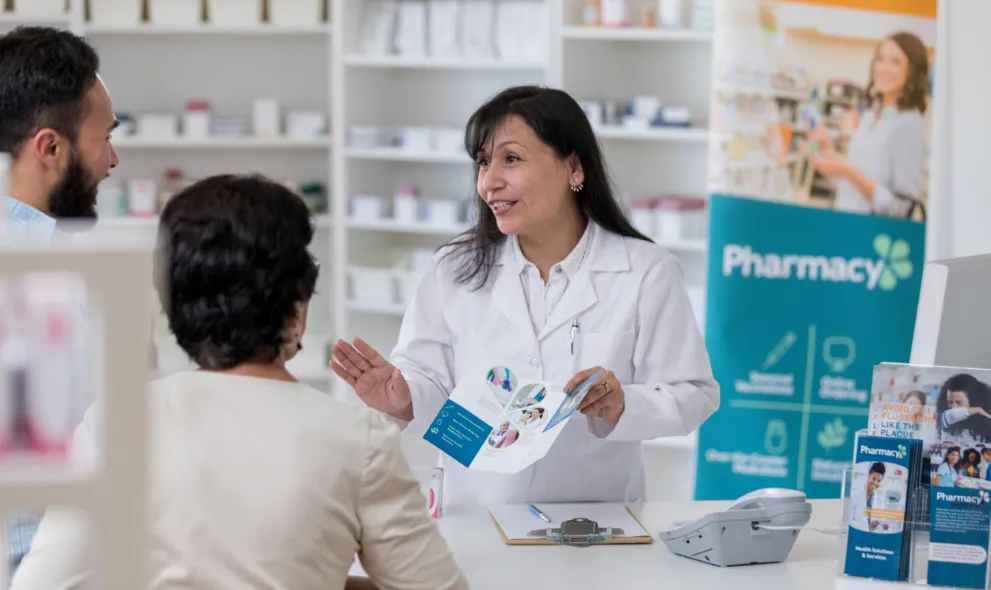 Pharmacy speaking to patients at pharmacy counter