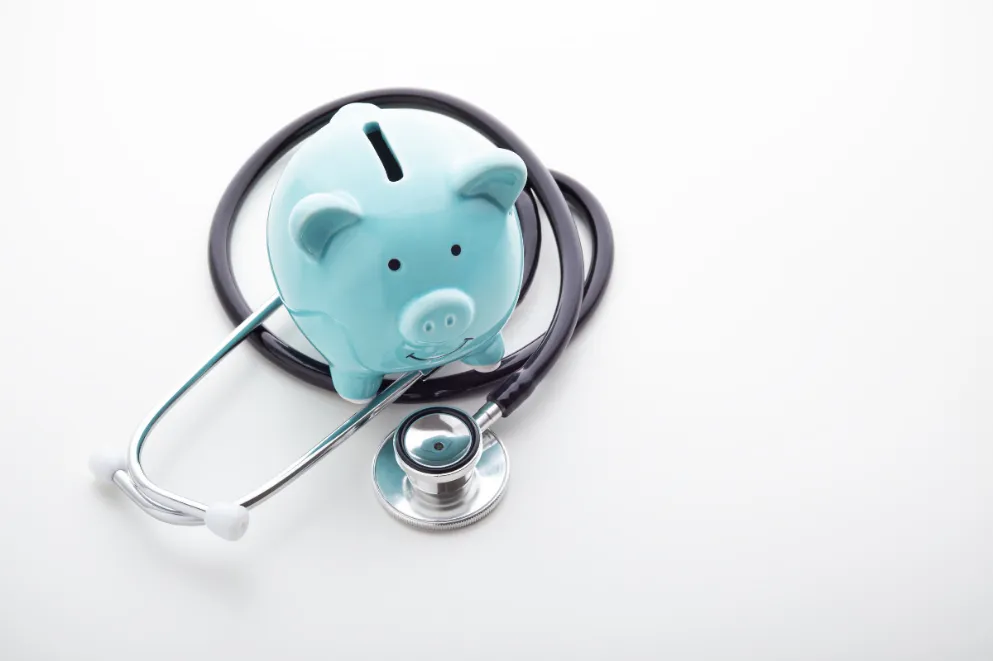 Piggy bank with stethoscope on white background