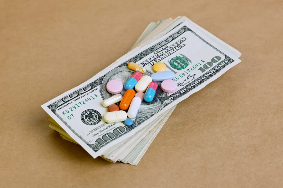 Pills and tablets on top of US paper currency