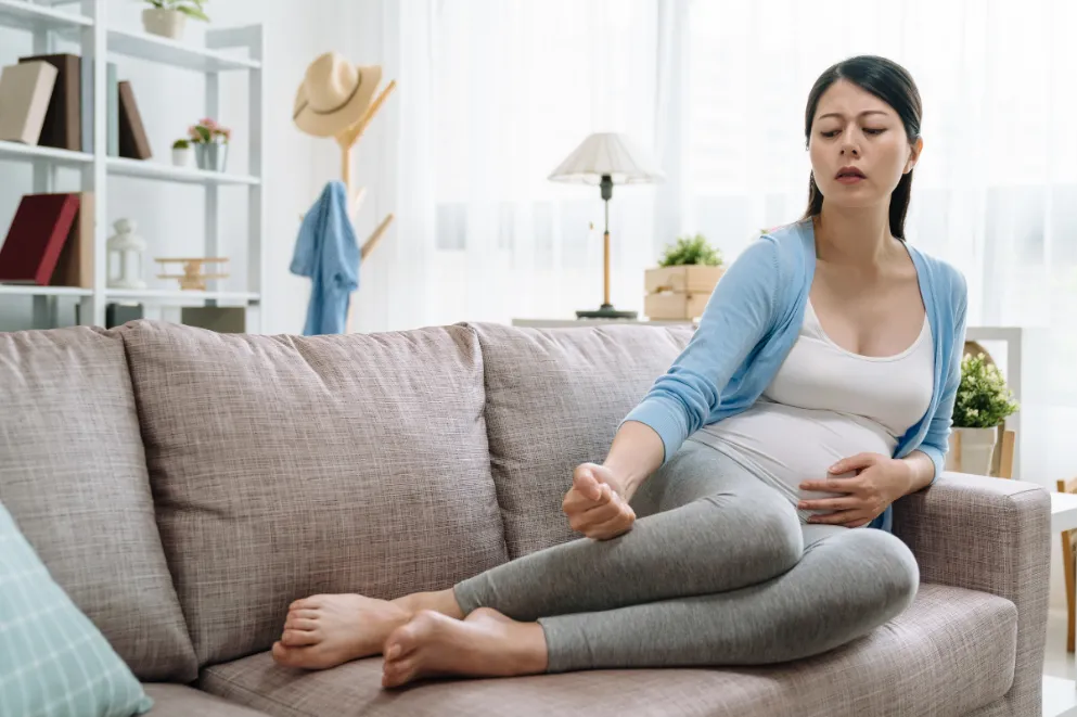Pregnant woman on sofa with feet up
