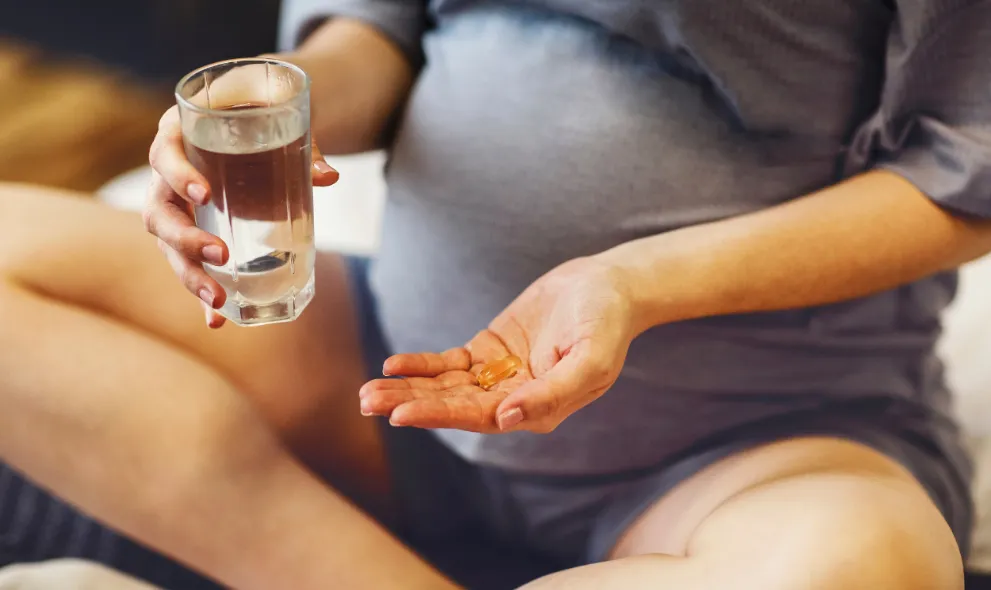 Pregnant woman taking prenatal vitamin