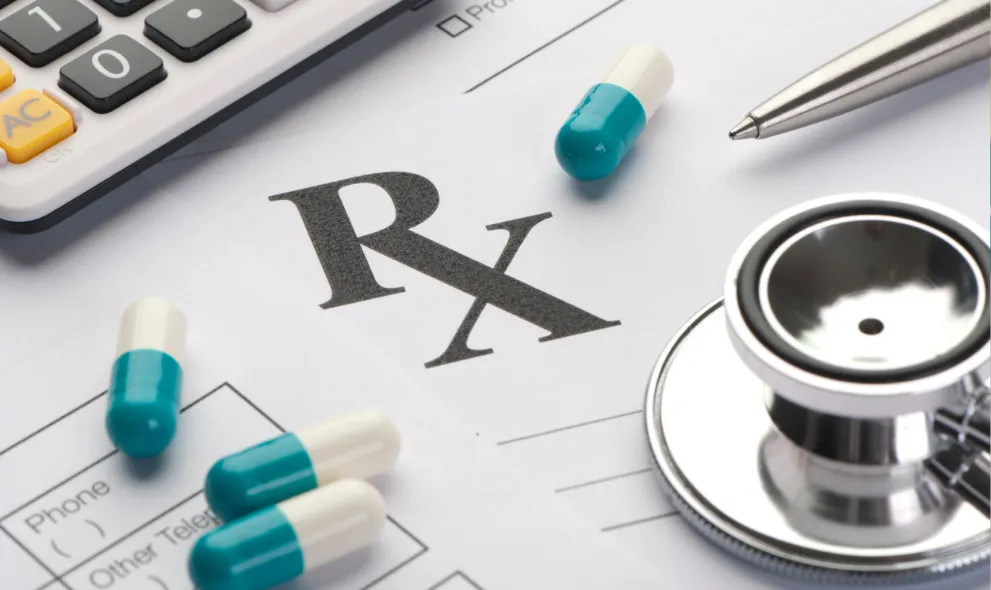 Prescription form on a desk with stethoscope pills and pen