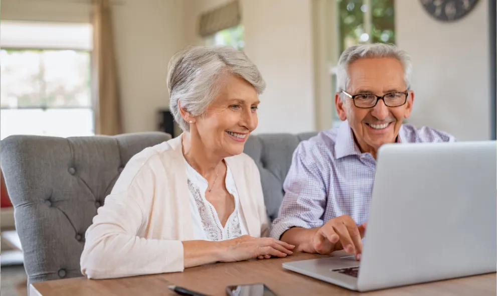 Retired couple comparing pharmacy prices on laptop