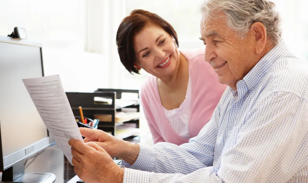 Senior couple working on computer at home