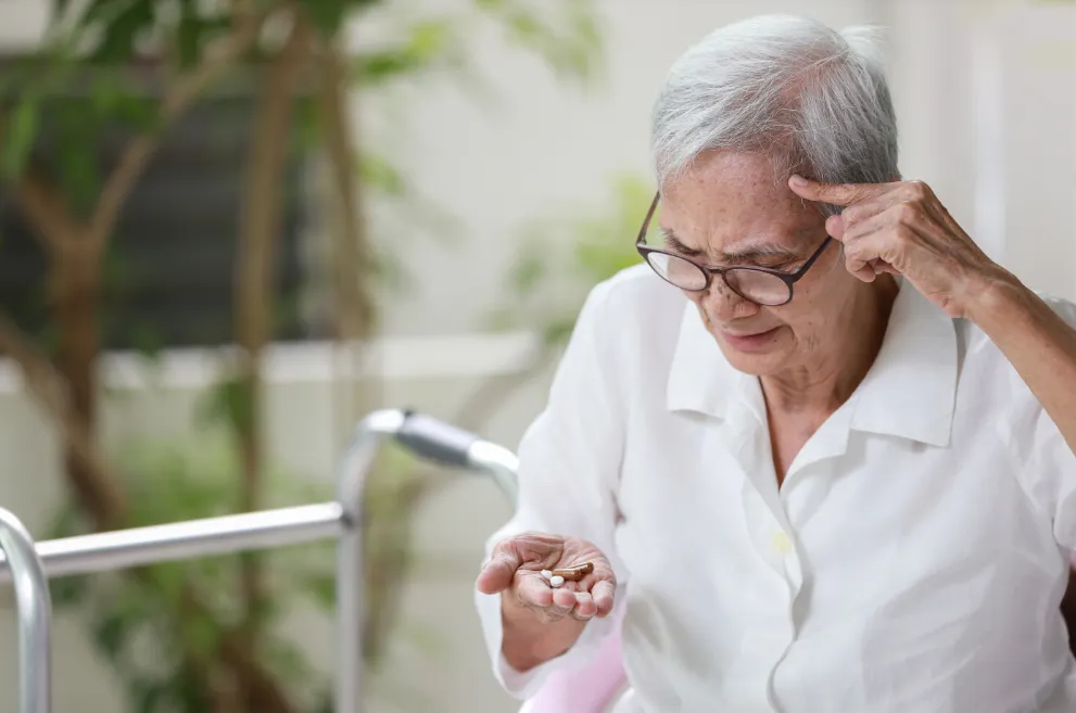 Senior patient looking at pills