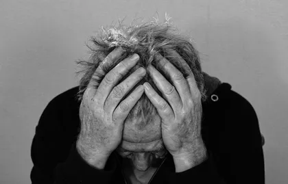 Depressed man holding head in his hands