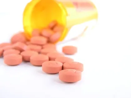 Prescription bottle spilling out pills