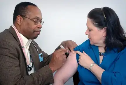 Doctor administering flu shot to patient