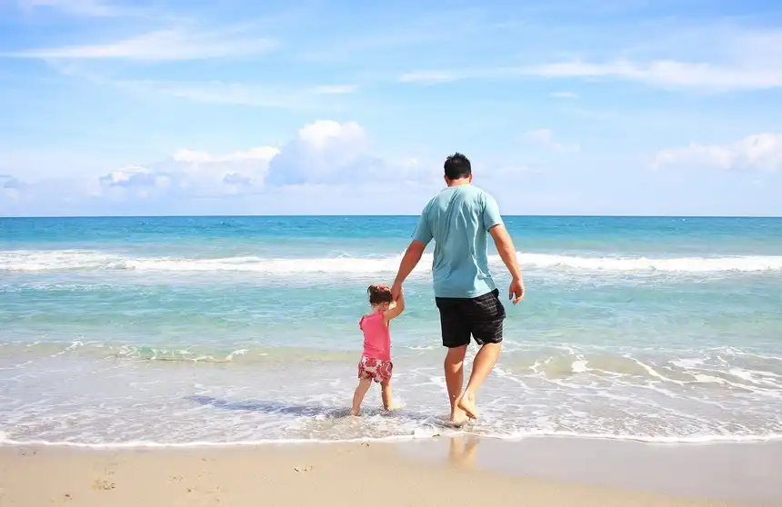 Father and daughter playing safely in the ocean