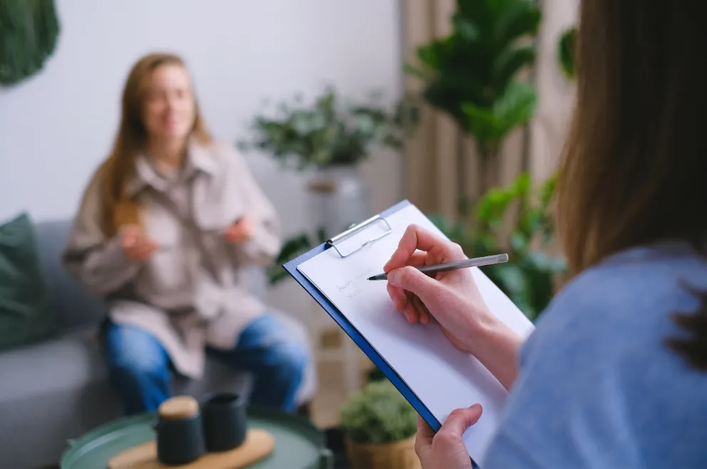 Therapist taking notes in session with female patient